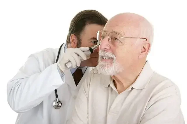 A doctor is examining an older man's ear.