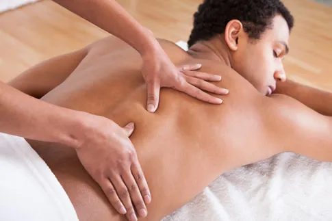 A man receiving a relaxing massage at a spa.