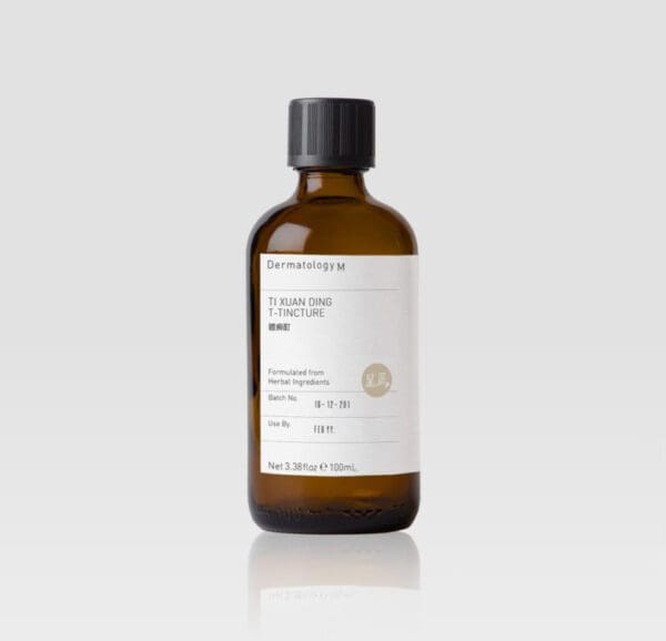 A bottle of TI XUAN DING T-TINCTURE - DERMATOLOGY M on a white background.