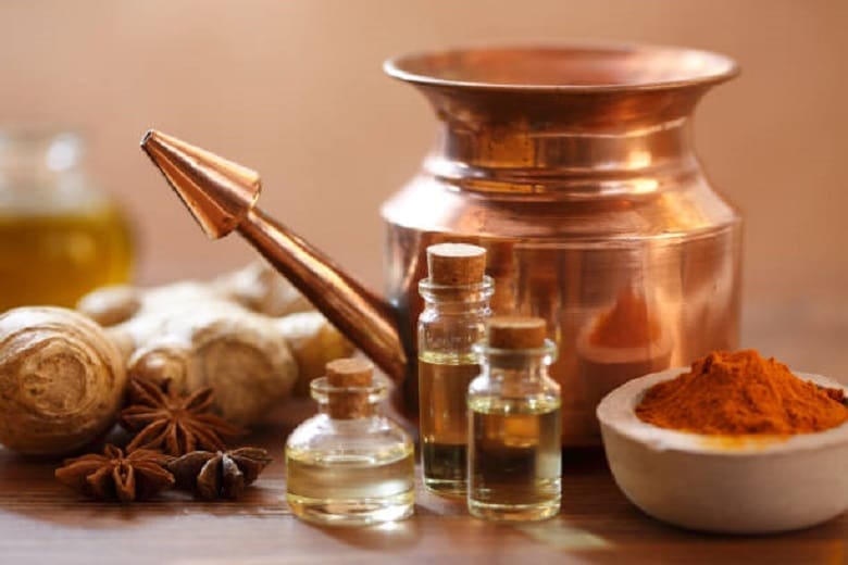 Essential oils and spices used in Chinese Medicine on a wooden table.